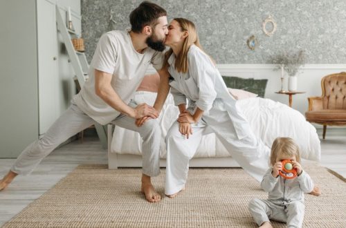 Playful morning with parents stretching and a toddler playing in the bedroom.